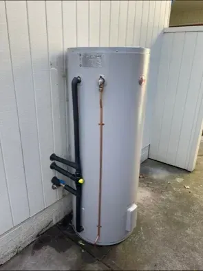 Grey Water Heater Cylinder Attached to a White Wall — Precise Plumbing & Drainage In Conder, ACT