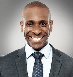 A man in a suit and tie is smiling for the camera.