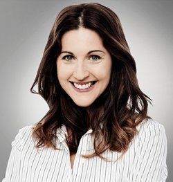 A woman in a striped shirt is smiling for the camera