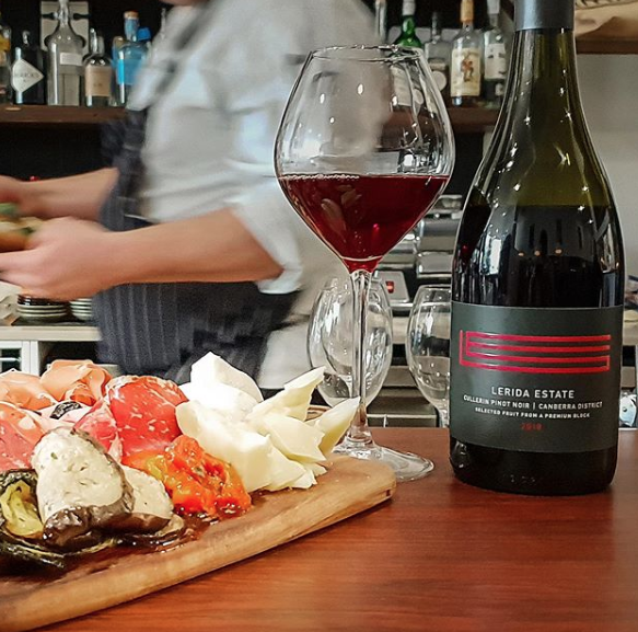A bottle of extra estate wine sits on a wooden table