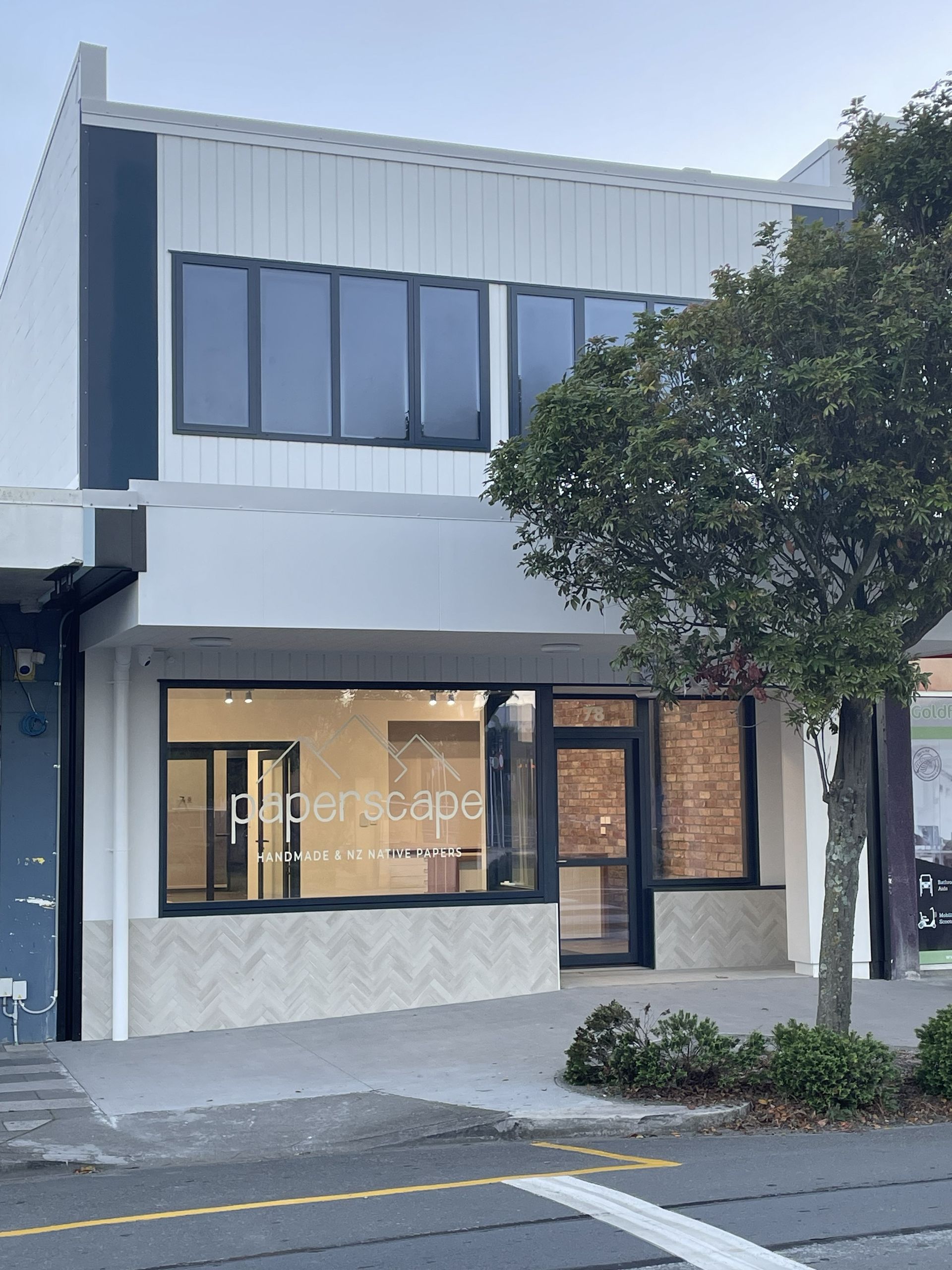 Modern bathroom with white sinks, circular mirrors, and glass shower.