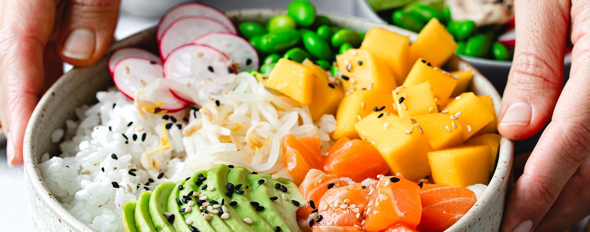 Poke Bowl, fish, rice, avocado, edamame, radish in a bowl