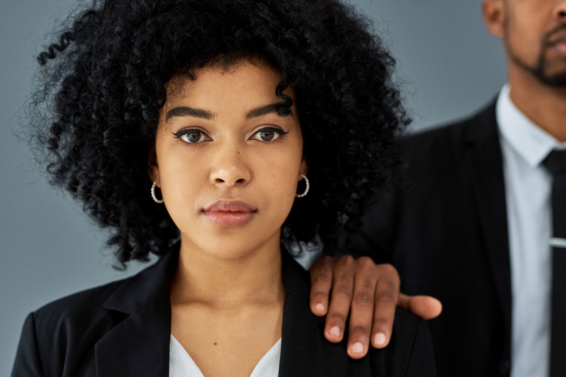 A man is putting his hand on a woman's shoulder.