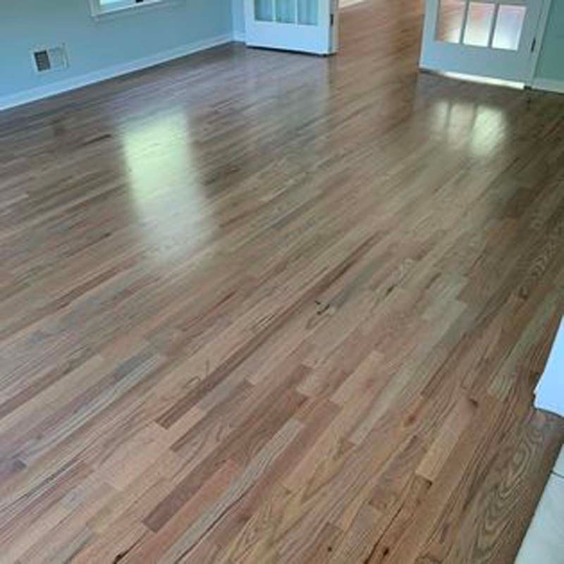 A living room with hardwood floors and white walls.