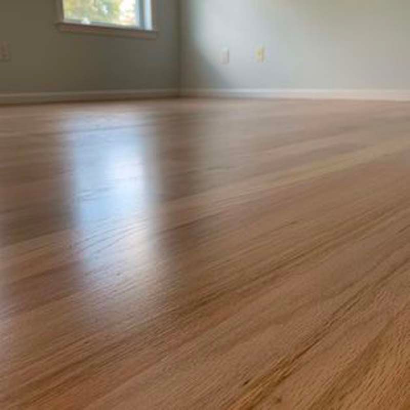 A close up of a wooden floor in a room with a window.