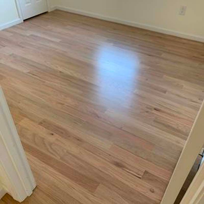 A bedroom with a wooden floor and white walls.