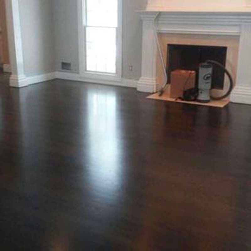 A living room with a fireplace and a vacuum cleaner on the floor.