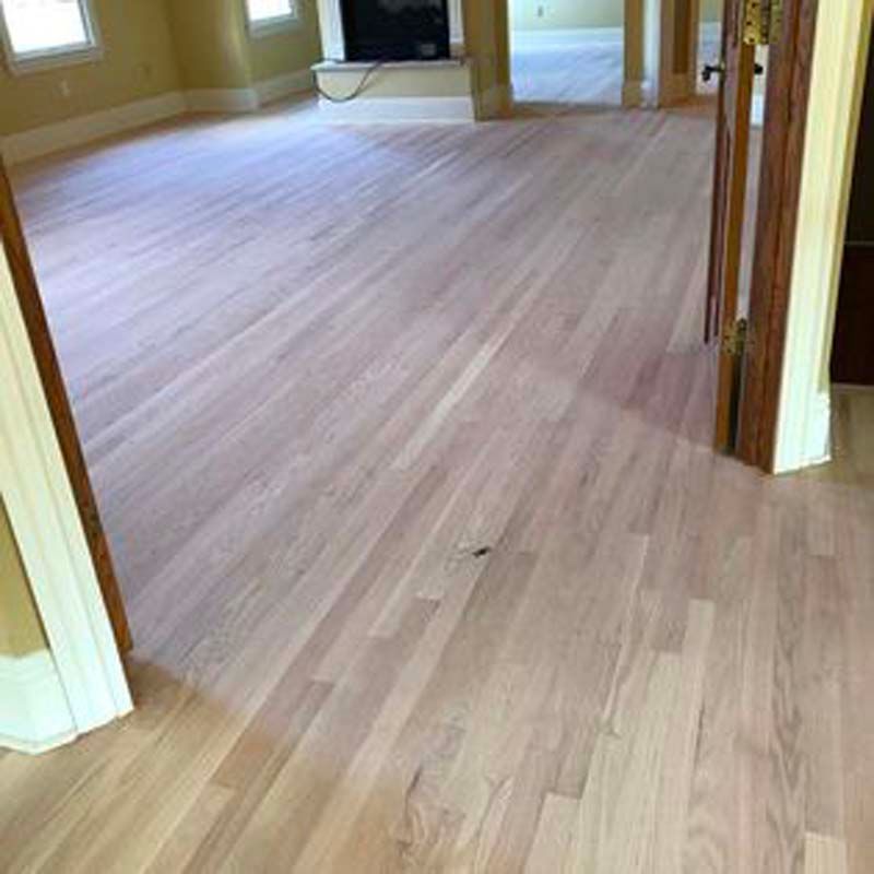 A living room with hardwood floors and a fireplace.