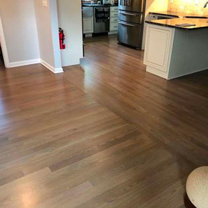 A kitchen with hardwood floors and stainless steel appliances.