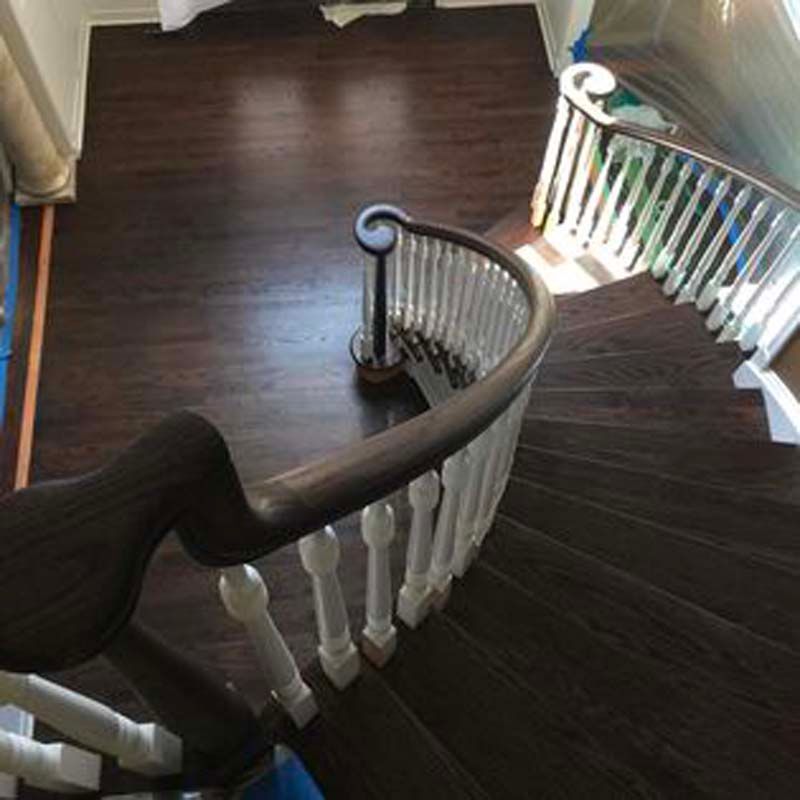 A spiral staircase with a wooden railing and a wooden floor.