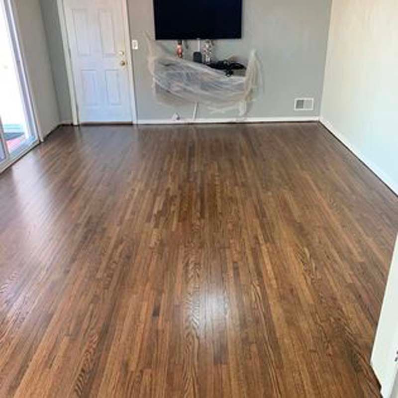 A living room with hardwood floors and a flat screen tv on the wall.