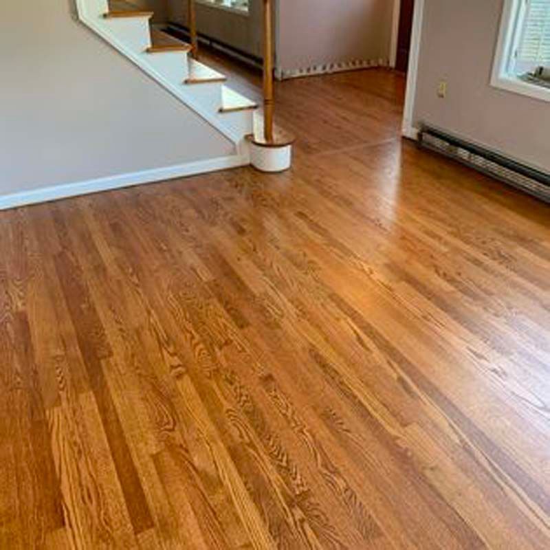 A living room with hardwood floors and stairs.