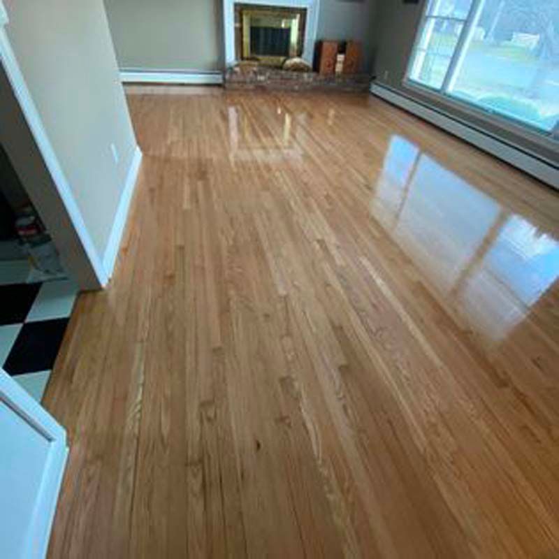 A living room with hardwood floors and a fireplace.