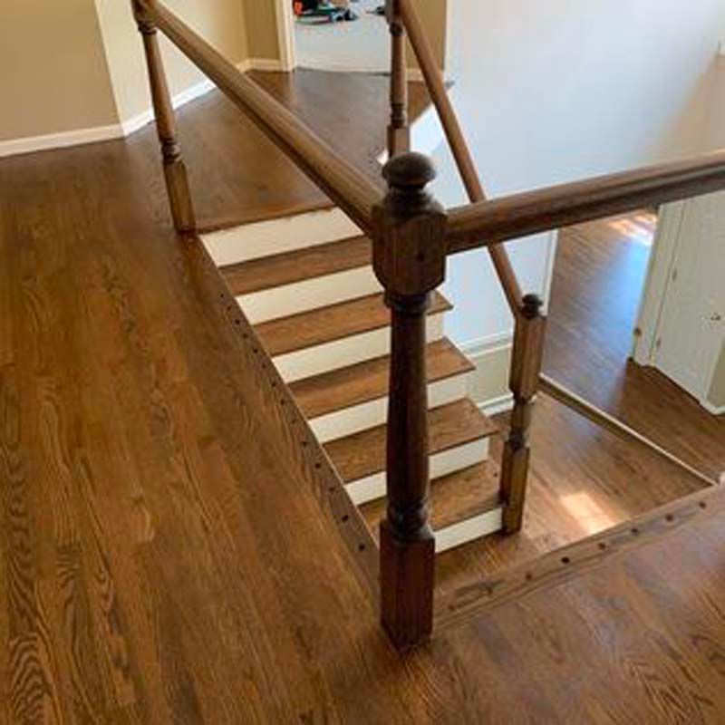 A wooden staircase with white steps and a wooden railing in a house.