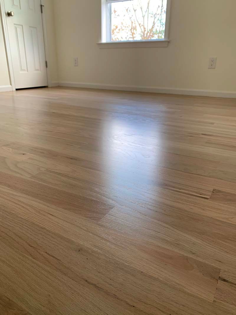 A room with a wooden floor and a window.