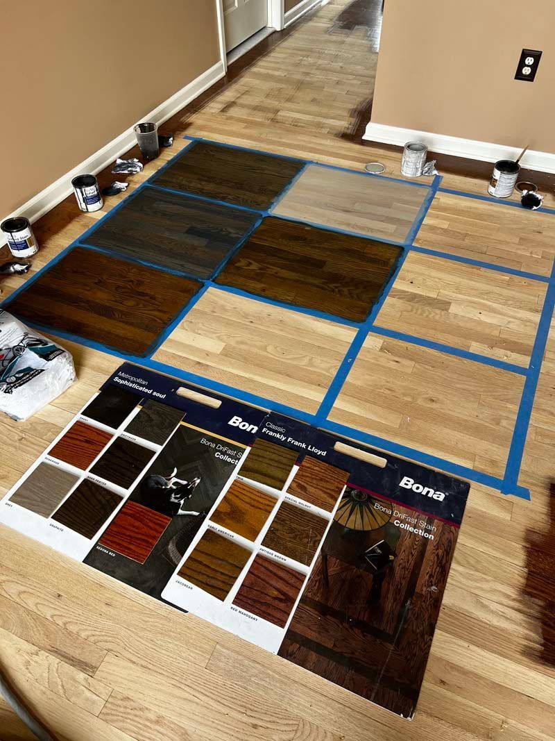 A wooden floor is being painted in a room.