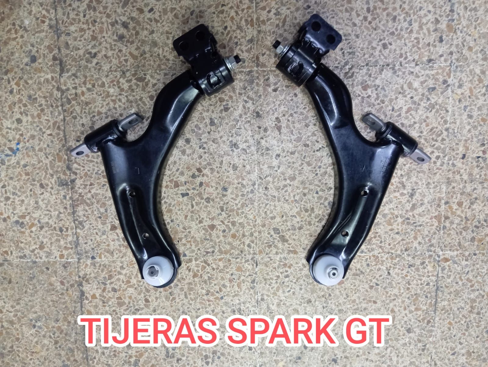 Dos brazos de control de suspensión de automóvil de color negro, etiquetados