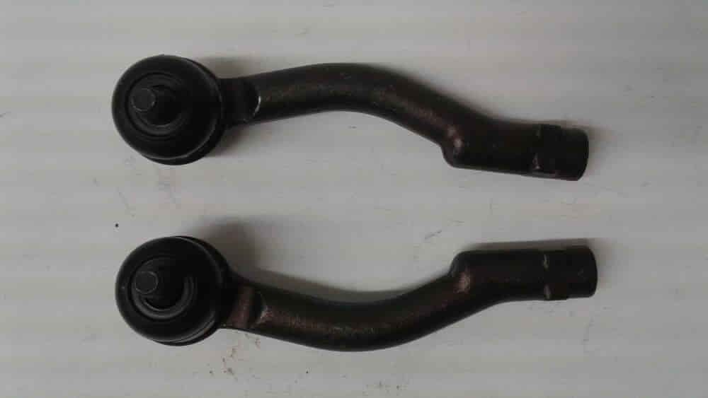 Dos varillas metálicas curvas de color negro con extremos circulares, dispuestas horizontalmente sobre un fondo claro.