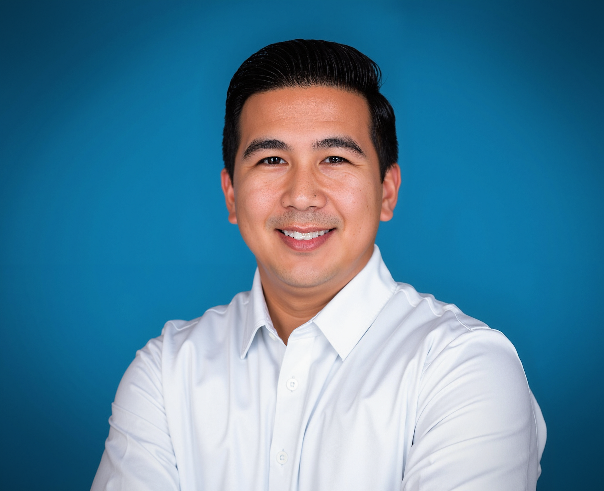 Agency owner Matthew Casabar is wearing a white shirt and smiling for the camera.