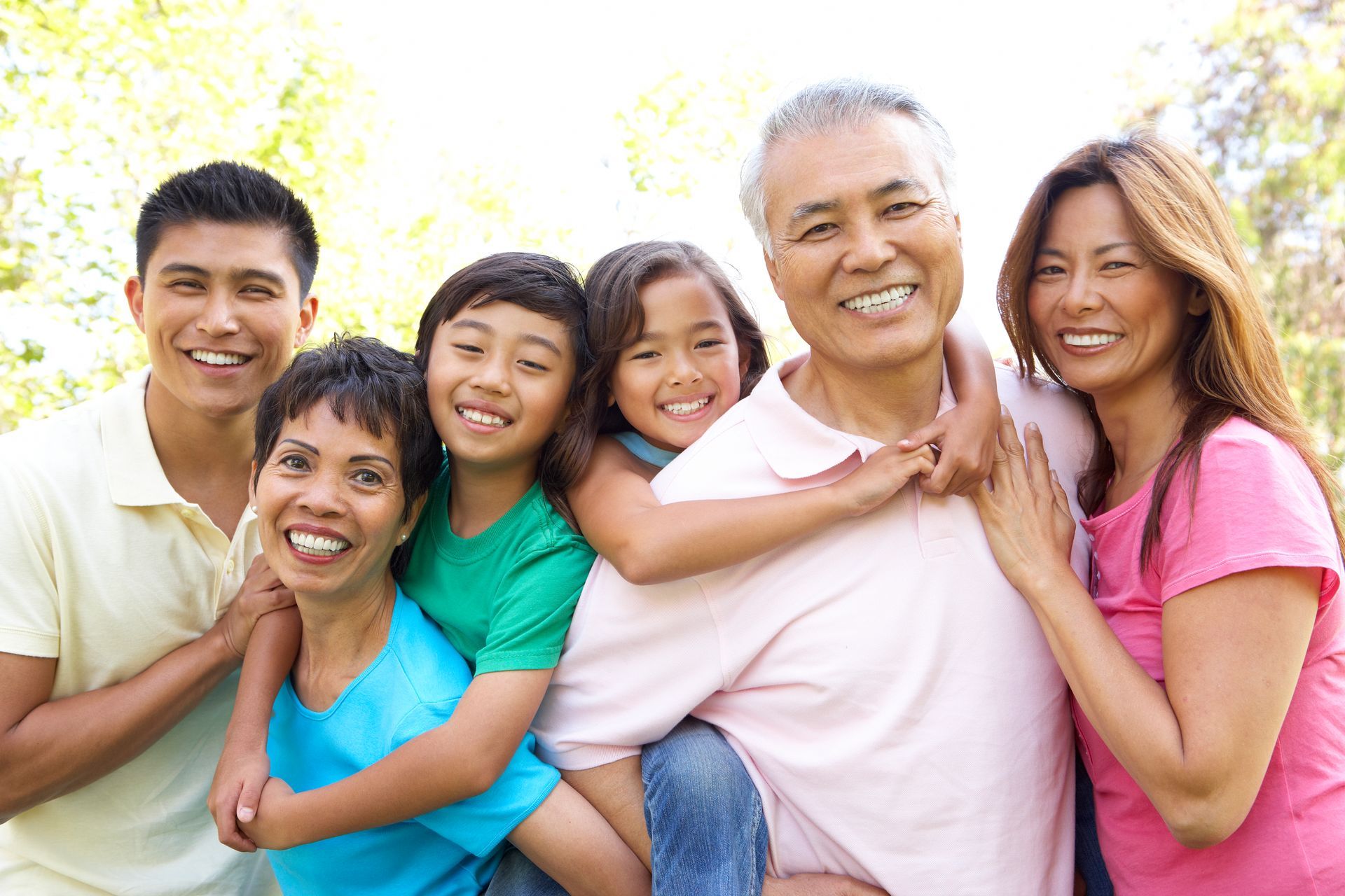 A family is posing for a picture together in a park.