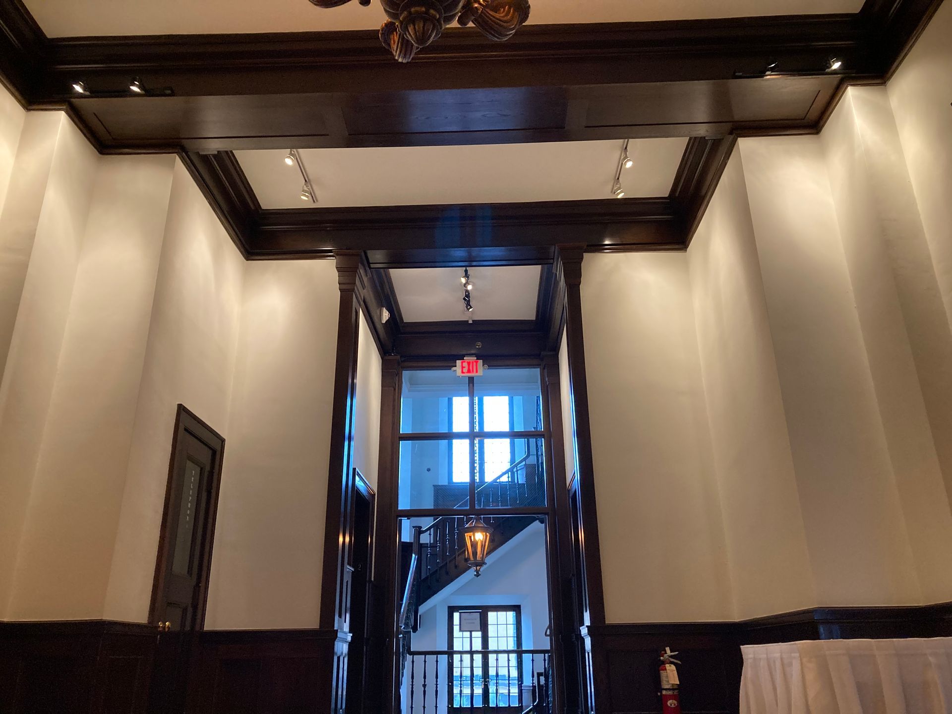 A hallway in a building with a red exit sign