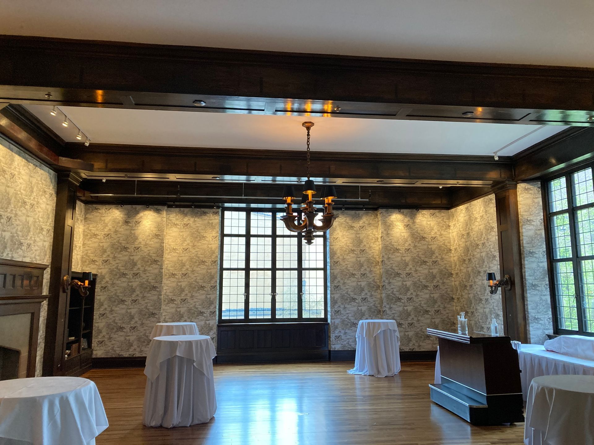 a room with tables and a chandelier hanging from the ceiling