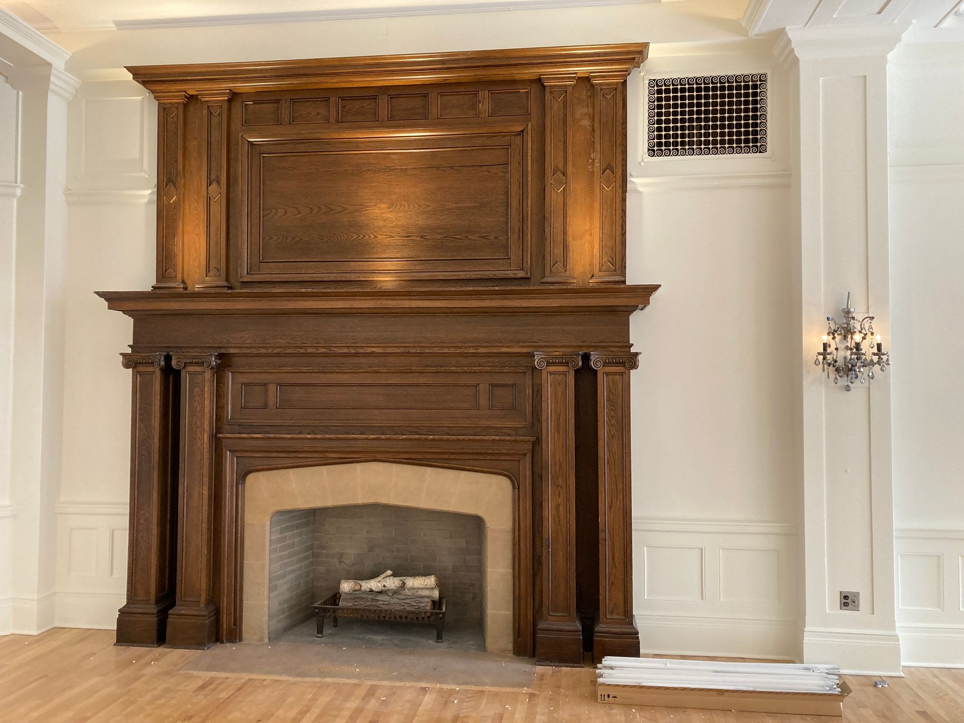 A fireplace with a wooden mantle in an empty room