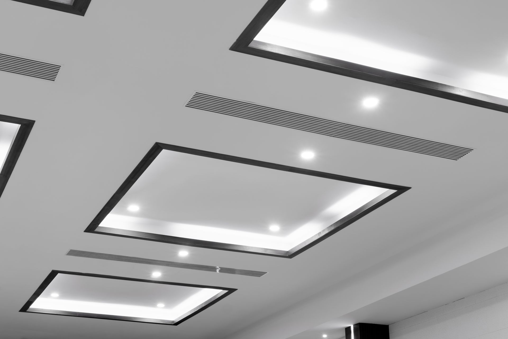 White ceiling with recessed rectangular lighting and dark trim.
