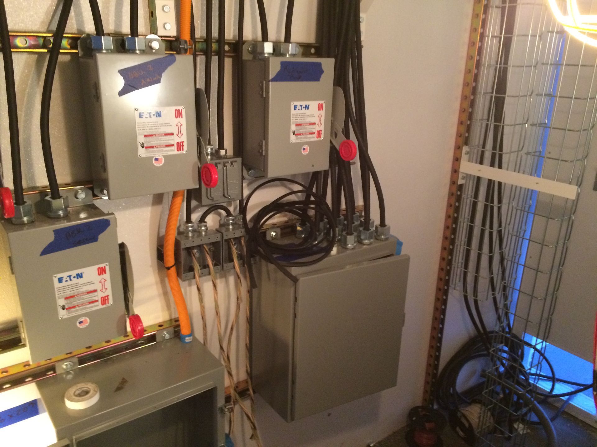 A bunch of electrical boxes are hanging on a wall