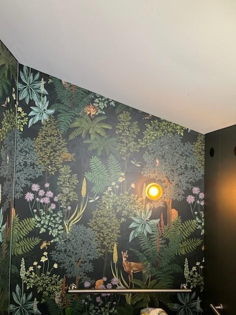 A bathroom with a floral wallpaper and a light on the ceiling