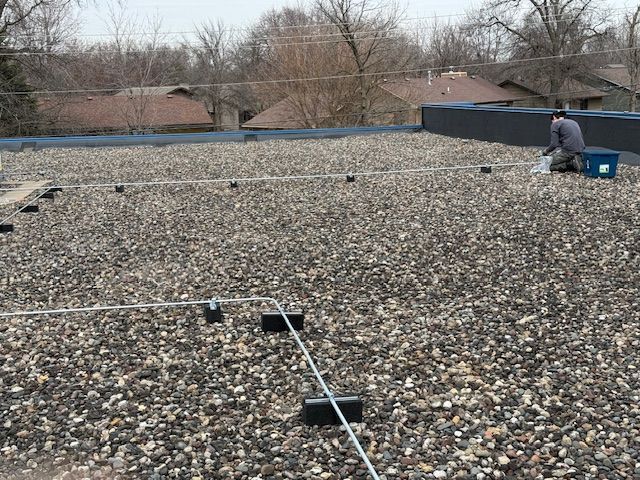 A man is working on the roof of a building