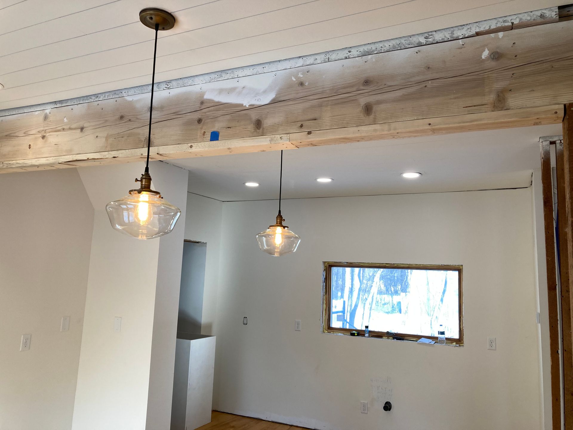 A living room with two pendant lights hanging from the ceiling and a window.