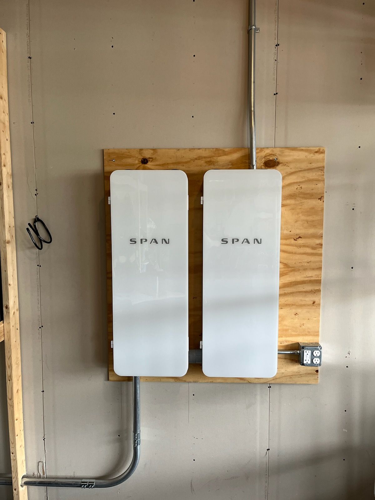 Two white boxes are sitting on a wooden shelf on a wall.