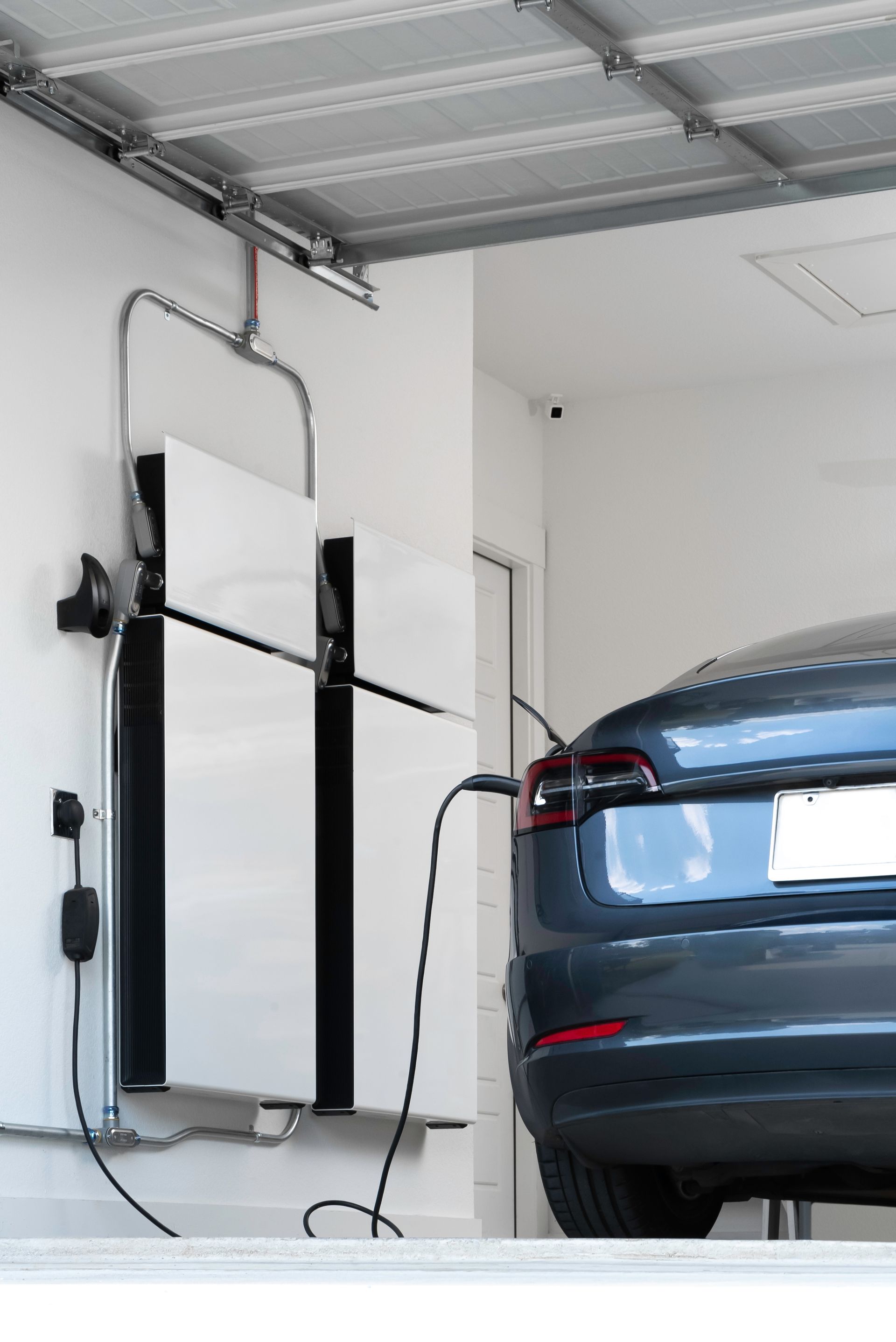 a tesla model 3 is being charged in a garage