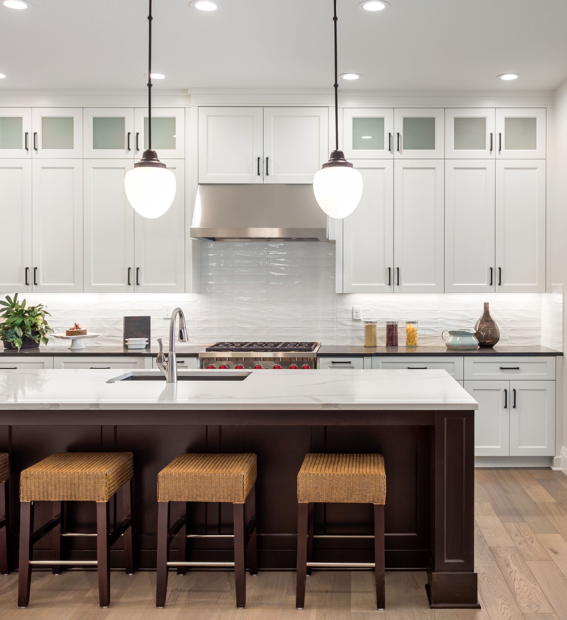 A kitchen with white cabinets and a large island