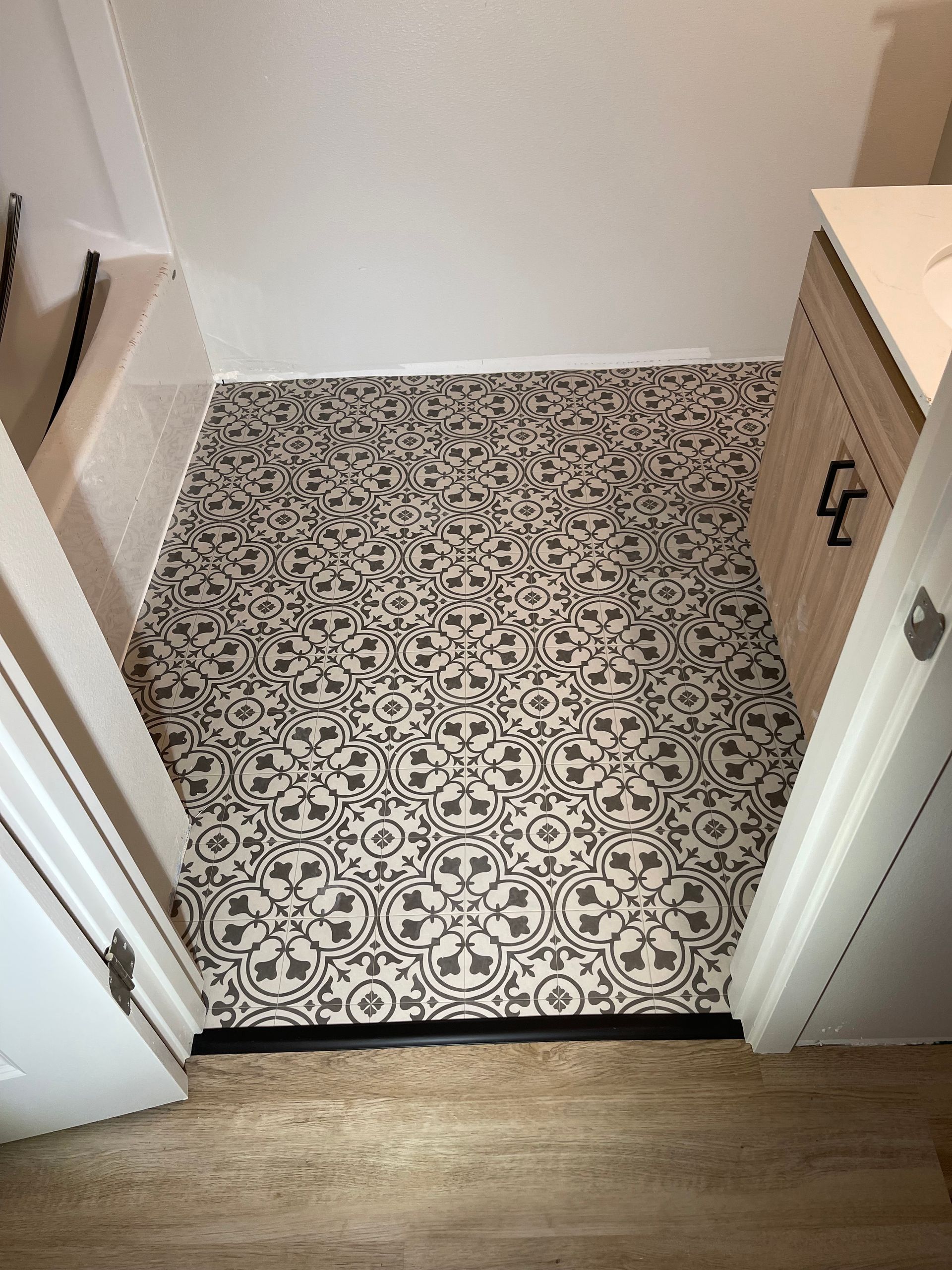A bathroom with a tiled floor and a sink.