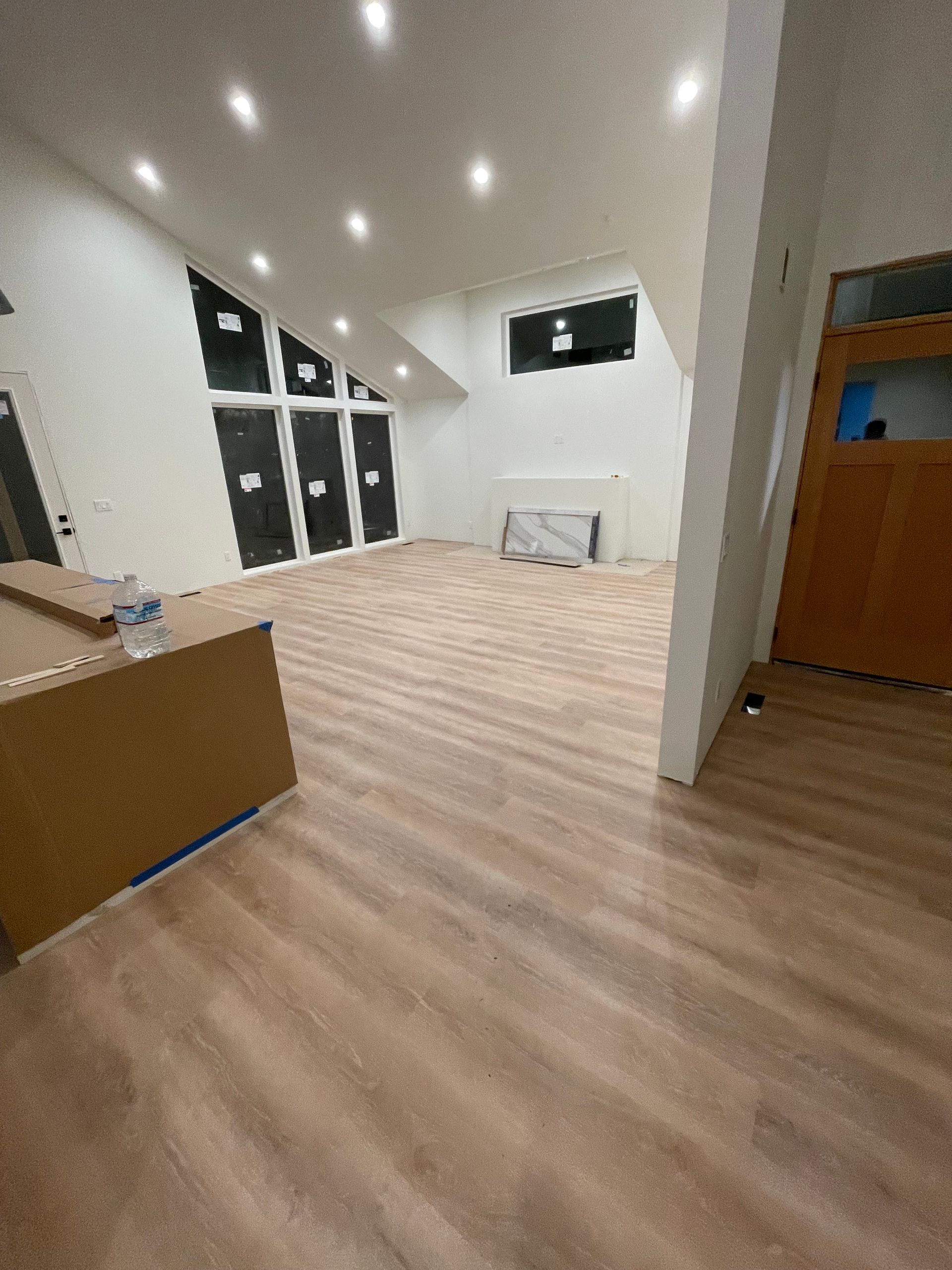 A large empty room with hardwood floors and white walls.