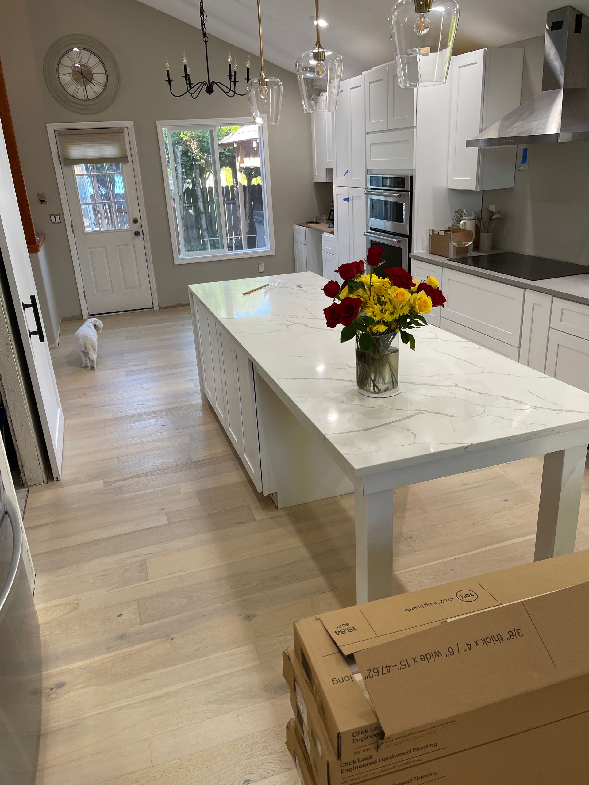 A kitchen with a large island and a vase of flowers on it.