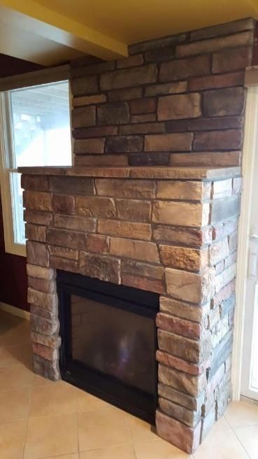 Stone fireplace with black framed firebox, built into a corner.