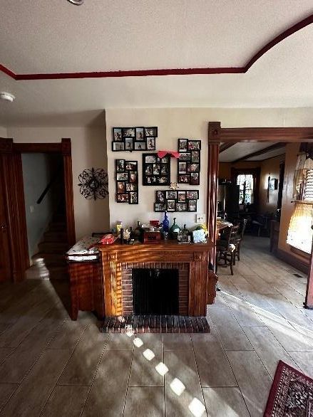 Living room with fireplace, framed photos, and a view into a dining area.