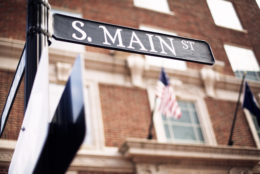 A street sign for s. main st. in front of a brick building
