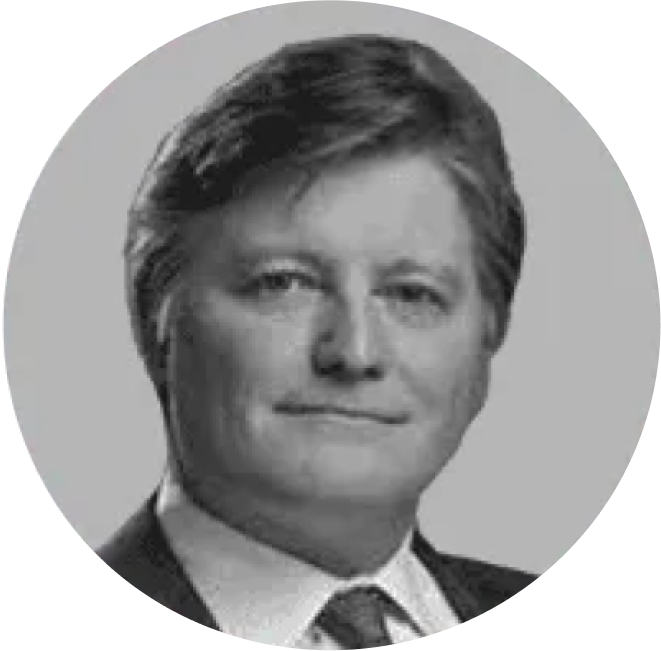 A man in a suit and tie is smiling in a black and white photo