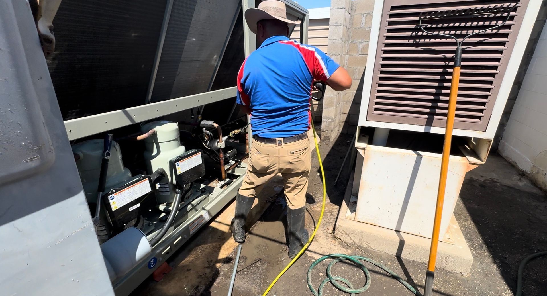 Man Cleaning an Outdoor Air Conditioning Unit - Fort Worth, TX - A/C Kives Heating & Air Conditioning