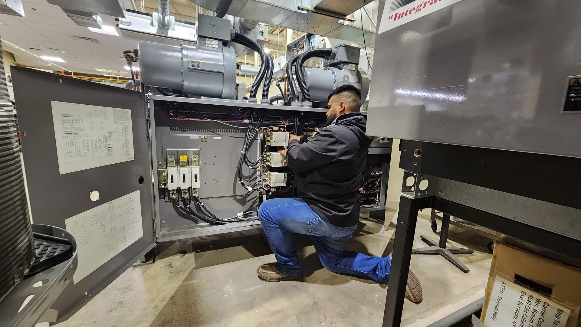 A man is kneeling down working on a machine in a room - Fort Worth, TX - A/C Kives Heating & Air Conditioning