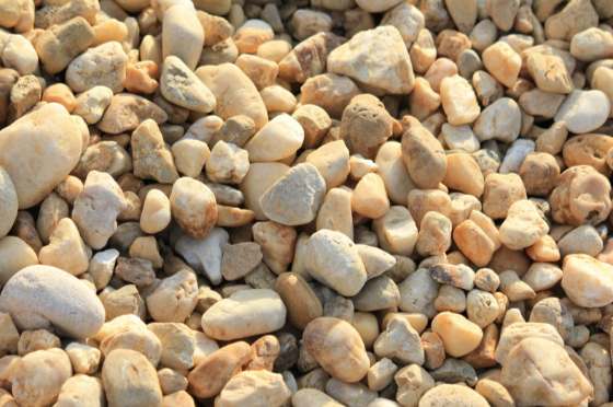 A pile of river rocks is sitting on the ground.