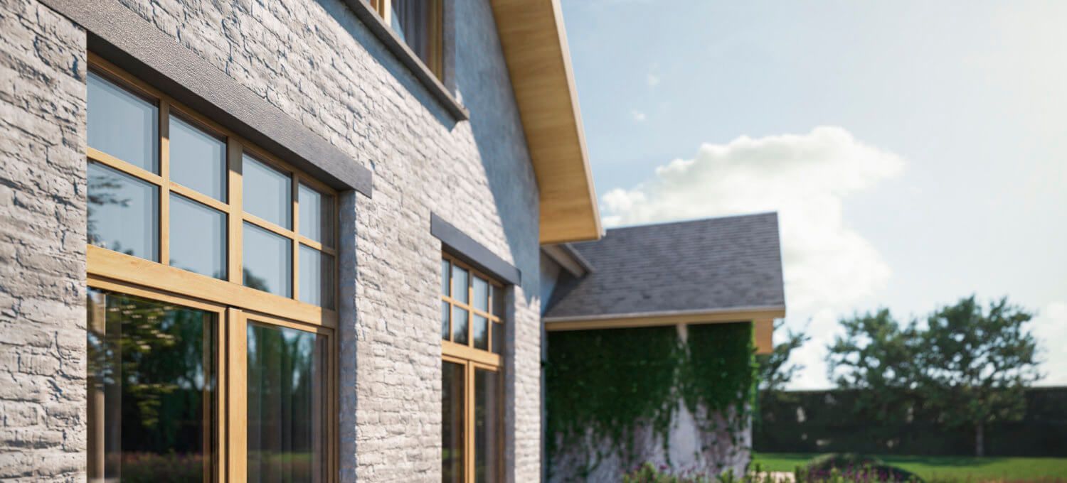 Een bakstenen huis met veel ramen aan de zijkant.