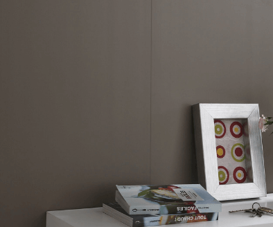 Een fotolijstje met cirkels erop staat op een tafel naast een boek