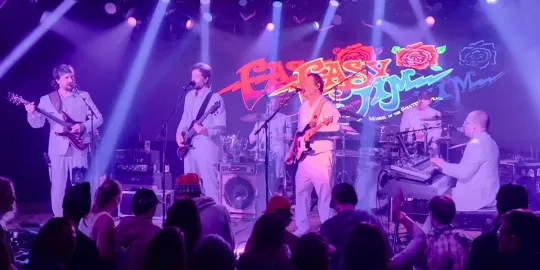 A group of people are playing instruments on a stage in front of a crowd.