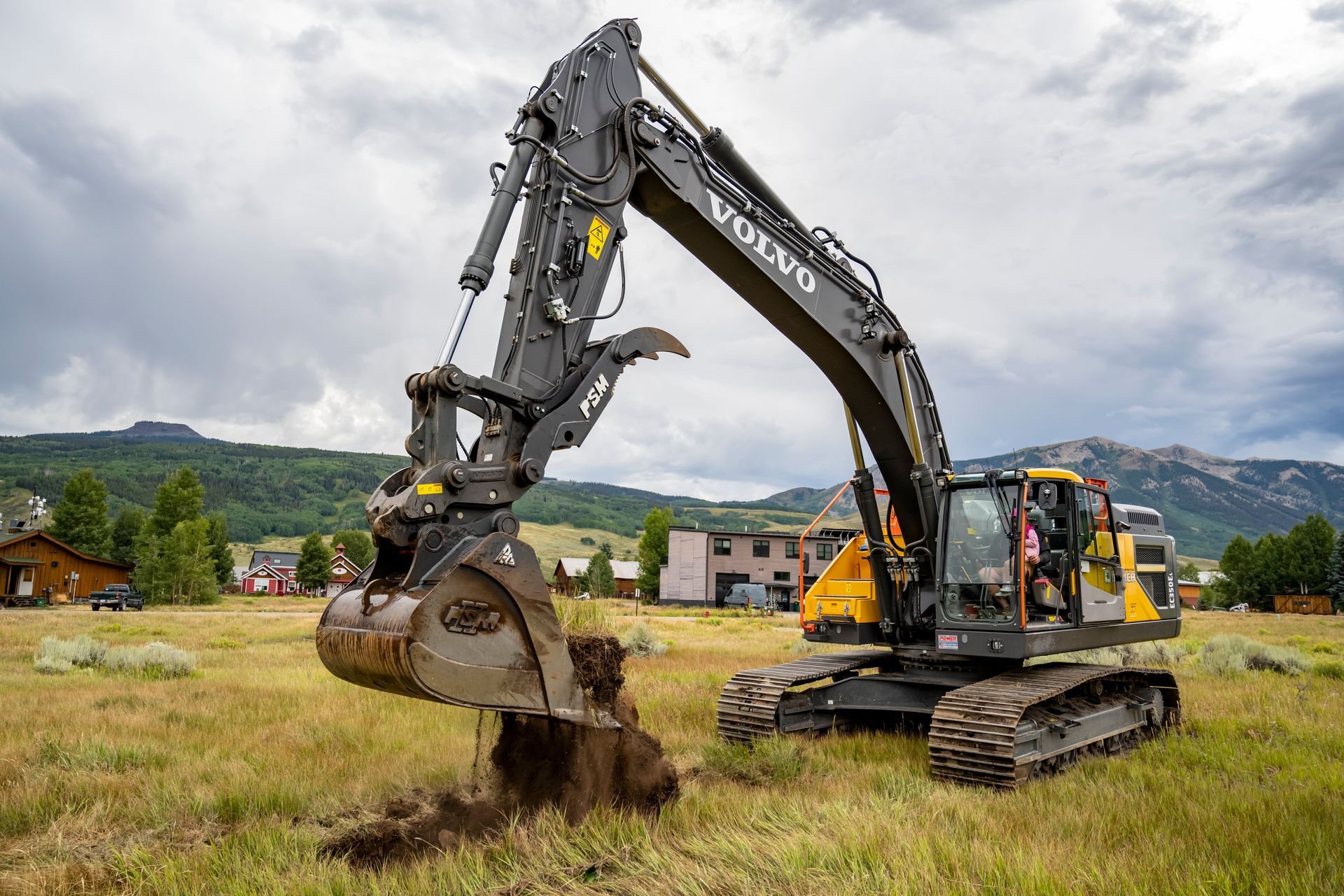 A large excavator is digging a hole in a field.