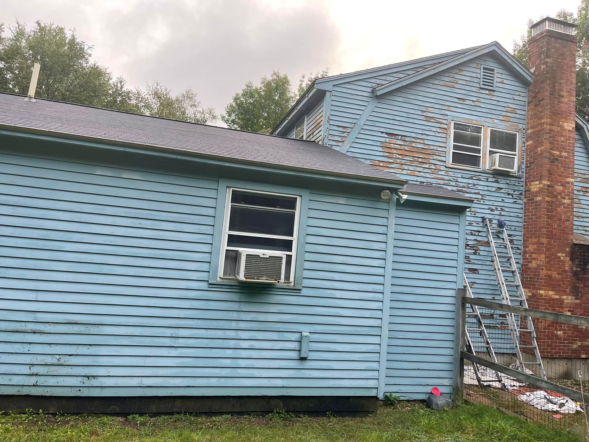 Back of a Blue House with Ladder and Chimney — North Hampton, NH — MG Painting And Hardwood Floor